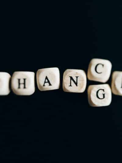 scrabble letters on a black background that spell out "chance" but with a "g" beneath the "n", so they could also spell out "change"