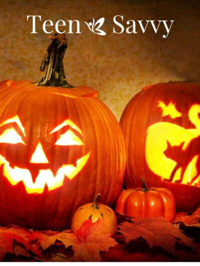 Two carved jack-o-lanterns, one with a smiling face, one with a cat arching its back.