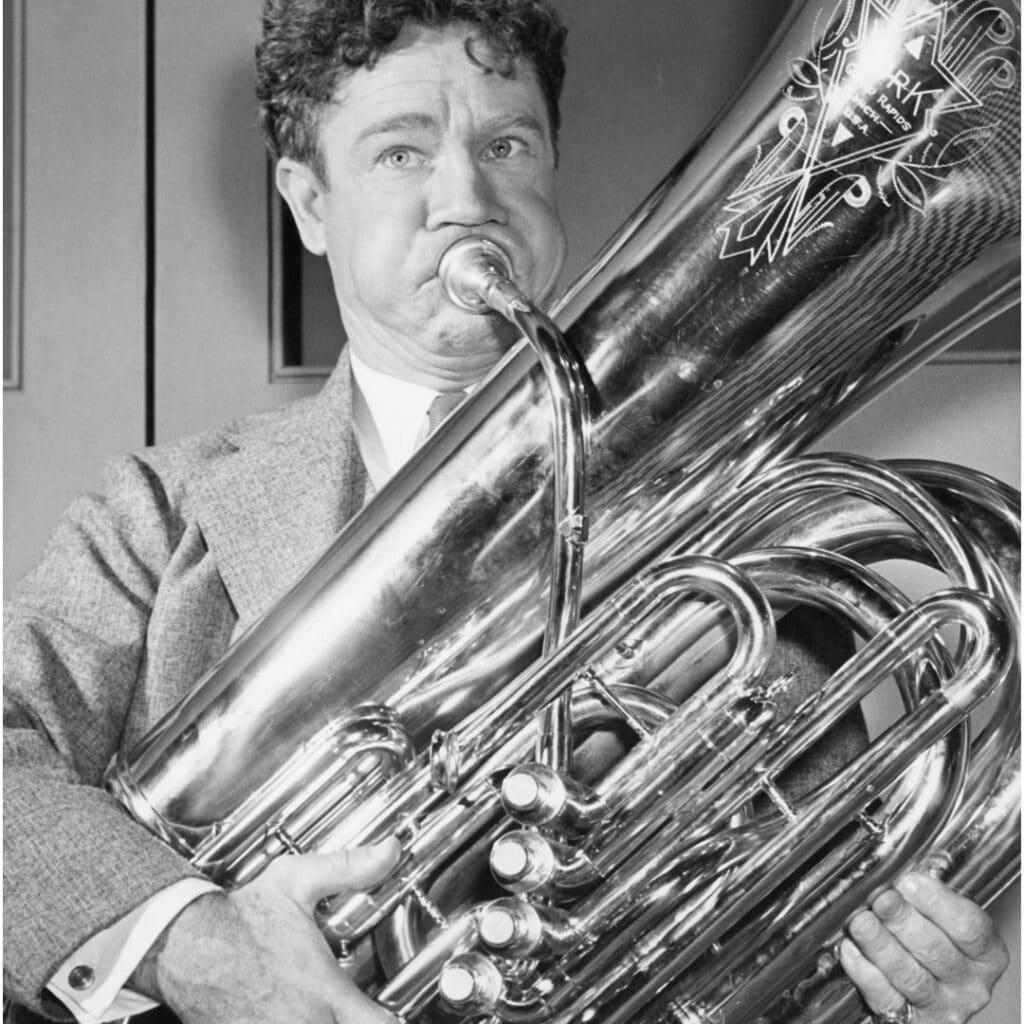 Black and white photo of a man playing a tuba