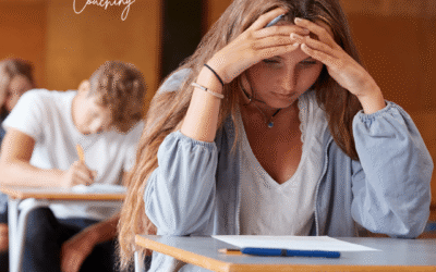 Teenage girl looking down at school work with concern in a classroom full of other students working.