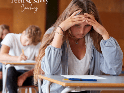 Teenage girl looking down at school work with concern in a classroom full of other students working.